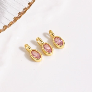 Detailed view of three pink oval zircon charms with gold plated settings for DIY jewelry