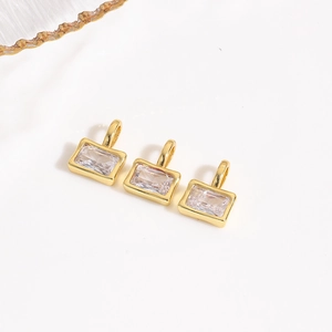 Close-up of three rectangle gold pendants with clear zircon stones for DIY jewelry