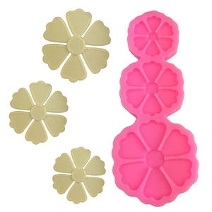 Détail de trois tailles de moules à fleurs en silicone avec échantillons floraux en argile