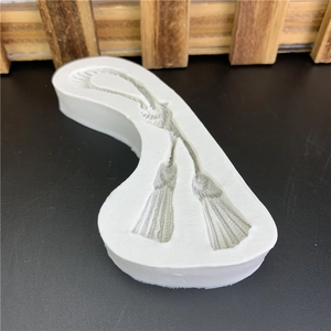 DIY flexible white silicone mold featuring detailed tassel and woven rope textures for baking