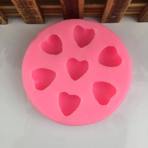 Pink circular silicone mold with seven heart cavities for DIY cake decorating and baking
