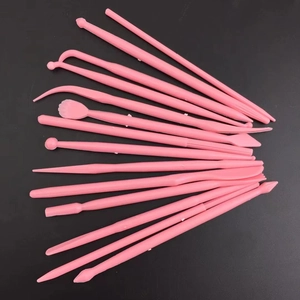14-piece pink clay modeling and fondant cake sculpting tools on a black background