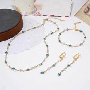 Platliggende set van gouden boze oog sieraden met witte parels op vintage decor