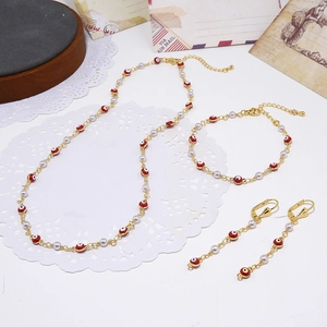 Bohemian sieradenset met evil eye ketting, armband en oorbellen op een kanten achtergrond