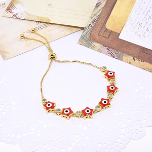 Adjustable gold star evil eye bracelet with red enamel and shimmering cubic zirconia