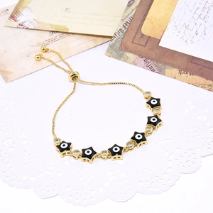 Adjustable gold plated evil eye star bracelet with zircon inlay on vintage postcard
