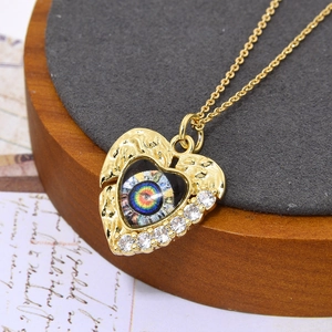 Detail van de gouden hart hanger met evil eye motief en zirkonia-accenten van dichtbij