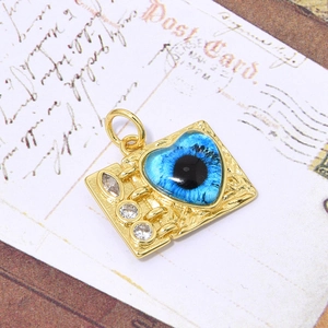 Macro-opname van gouden rechthoekige hanger met blauw hart oog en witte zirkoniasteentjes
