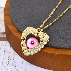 Macro-opname van gouden harthalsketting met boze oog en zirkoon op vintage papier