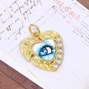 Macro detail van de gouden hart hanger met boze oog motief en zirkonia op briefkaart