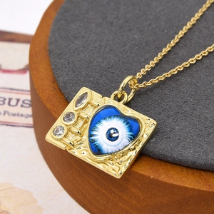 Detailopname van de gouden vierkante hanger met een hartvormig boze oog en zirkoonsteen