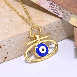 Gouden ketting met evil eye hanger van emaille op een stenen ondergrond
