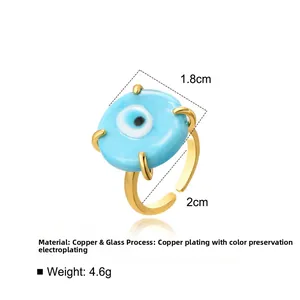 Macro detail of Turkish evil eye open ring with blue glass and gold plated copper band