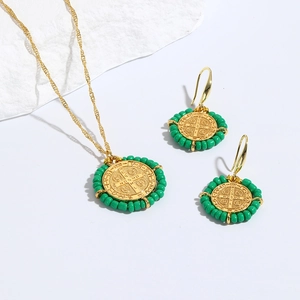 Detalle del conjunto de medalla de San Benito con cuentas de cerámica verde y dorado