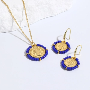 Detalle de un conjunto de joyas religiosas con cuentas cerámicas azules y San Benito