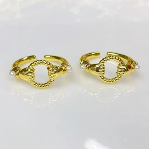 Detailed macro view of 18k gold plated open rings with hand-shaped pearl design