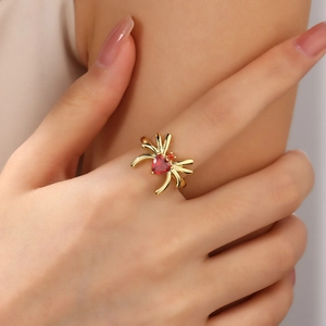 Dettaglio anello a ragno con zircone rosso a forma di cuore sul dito della modella