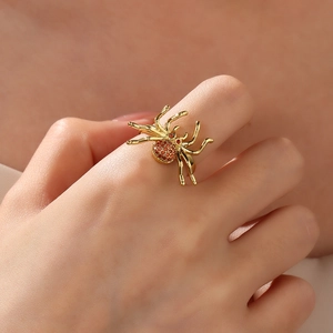 Dettaglio anello a ragno placcato oro 18k con zirconi rossi indossato al dito