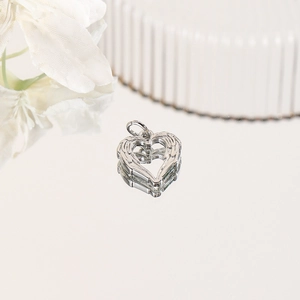 Detailed close-up of a silver heart pendant with delicate angel wing texture and ring