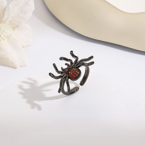 Dettaglio macro di anello a ragno nero con cristalli rossi e fascia aperta regolabile