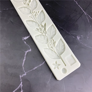 Silicone fondant mold with jasmine leaf and floral vine patterns on dark marble background