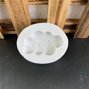 Smiling cloud silicone mold for DIY fondant and chocolate cake decorating on a dark table