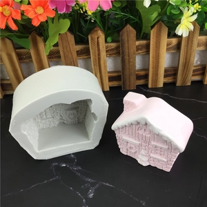 Detail view of 3D house silicone mold and finished pink plaster cottage with textures