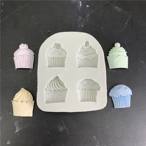 Close-up of 4-cavity silicone cupcake mold with colorful cream-textured cake toppers
