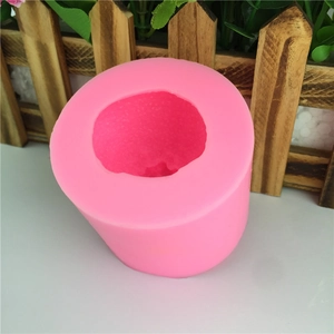 Rose pink cylindrical silicone mold for DIY chocolate and candle making on wooden background