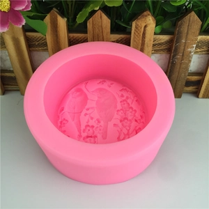 Pink silicone mold for baking and soap making with floral and bird relief patterns