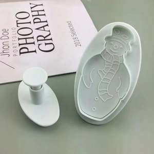 Light green 2-piece snowman cookie cutter set with spring-loaded embossing tool