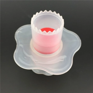 Cupcake corer tool with red silicone plunger and serrated edge on grey background