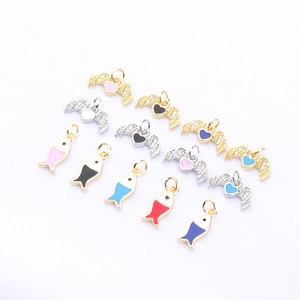 Detail view of colorful enamel wing and fish charms for DIY jewelry making
