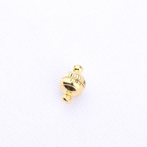 Detailed view of a ball-shaped magnetic jewelry clasp in gold finish for DIY crafts