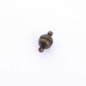 Macro view of vintage bronze magnetic jewelry clasp with vertical textured details