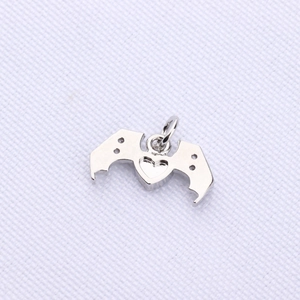 Detailed close-up of a silver heart-shaped pendant with bat wings for DIY jewelry making
