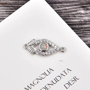 Macro shot of silver eye connector with opal and zircon for DIY jewelry making