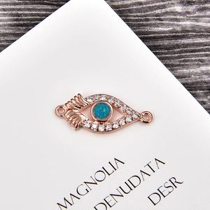 Macro detail of rose gold evil eye connector with opal and sparkling zircon stones