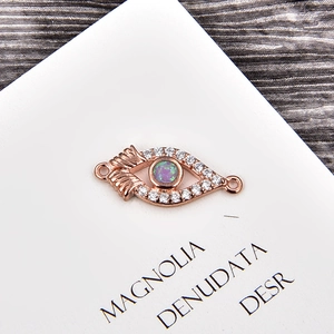 Detail of rose gold evil eye connector with opal stone and white cubic zirconia
