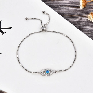 Detail of adjustable silver snake chain bracelet with opal Evil Eye charm connector