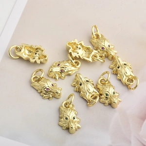 Vista de colgantes dorados de cabeza de animal con gemas para creación de joyas DIY