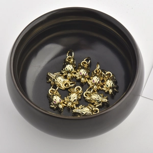 Detalle de colgantes de cabeza de león dorados con ojos de circón de colores en cuenco