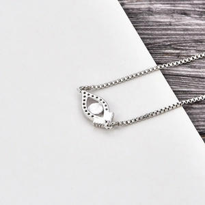 Close-up of silver-tone eye charm with pavé cubic zirconia and box chain connector