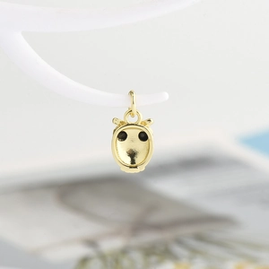 Detail of the golden owl pendant back side showing the smooth metal finish and loop