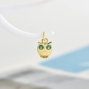 Charming owl pendant in gold plating with detailed feathers and green gemstone eyes
