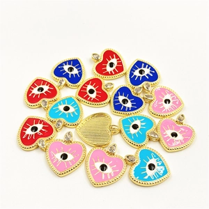 Detail view of heart-shaped evil eye pendants with colorful enamel and zircon accents