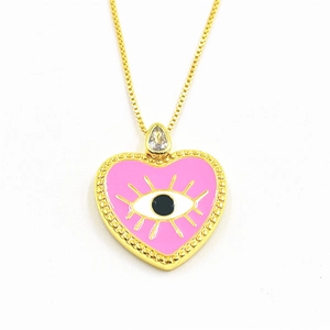 Detail of pink enamel heart pendant with golden evil eye and teardrop crystal charm