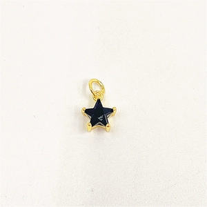 Macro detail of star-shaped pendant with black zircon stone and golden metal setting
