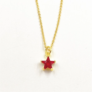 Close-up of gold star necklace pendant featuring a micro-paved red zircon stone detail