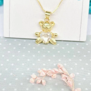 Detail of gold panda pendant featuring a heart-shaped zircon on a delicate box chain